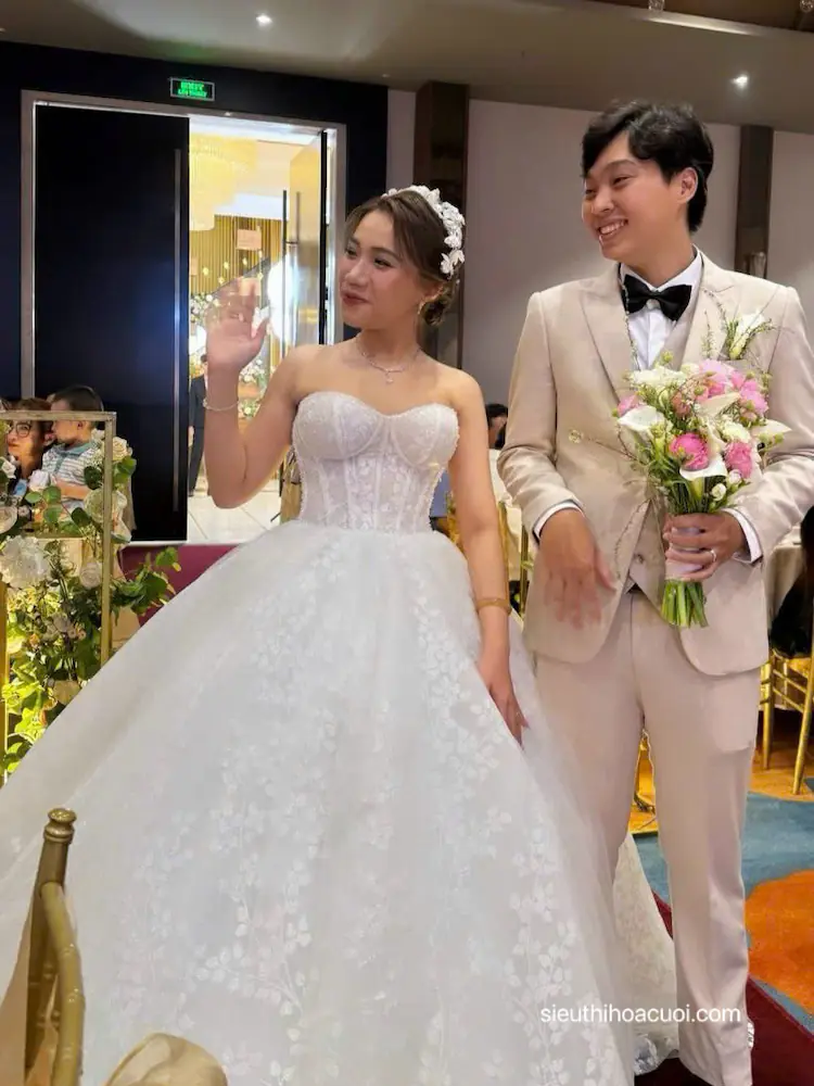 Hình ảnh kỷ niệm ngày cưới chú rể cầm bó hoa cầm tay cô dâu từ thương hiệu Siêu Thị Hoa Cưới